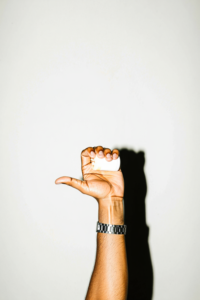 Hand holding a travel sized tube of KETRO, with a white background