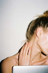 Woman rubbing neck at desk