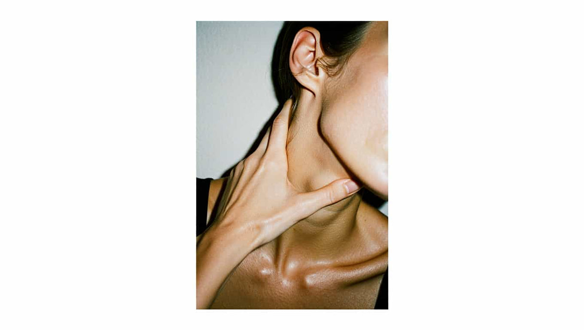 Person touching their neck and shoulders