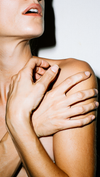 Woman touching neck and shoulder