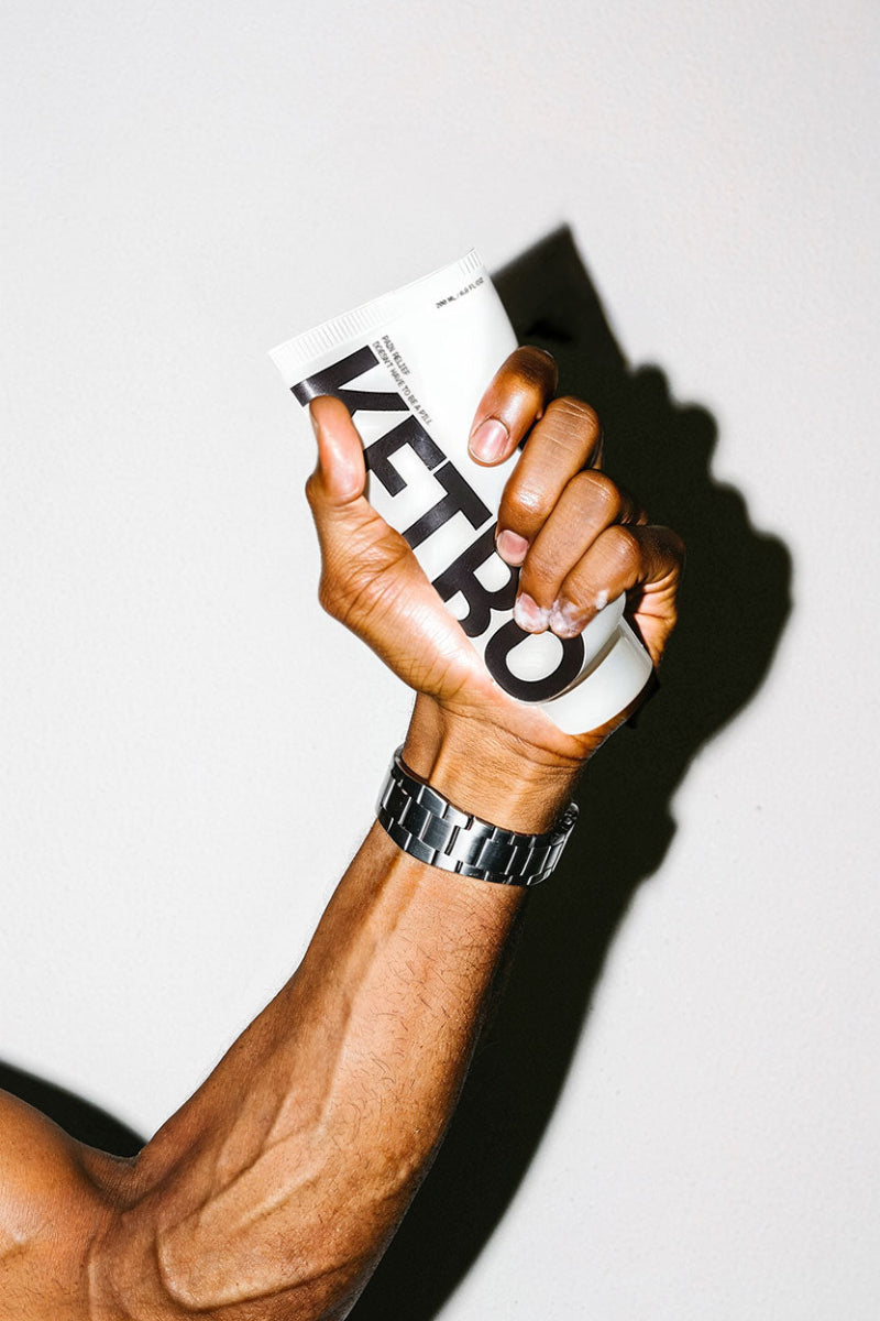 Hand holding a white tube with 'Ketro' branding against a light background