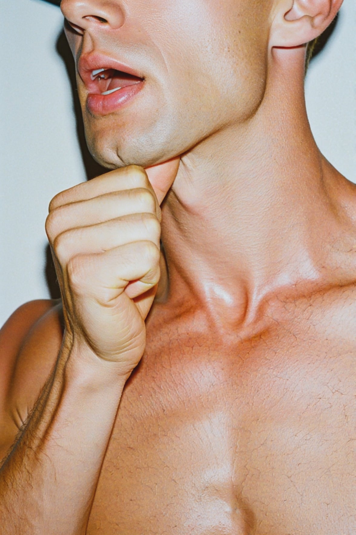 A video of a muscular man, rubbing underneath his chin with his right hand